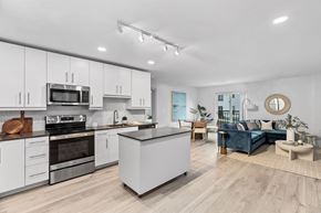 Scituate apartment for rent - an open kitchen and living room with white cabinets