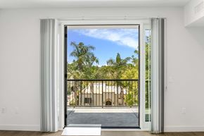Studio City apartment for rent - an open door leading to a balcony with trees and a building in the distance