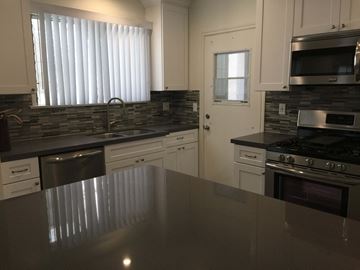 West Hollywood apartment for rent - a kitchen with an island and a stove and a door