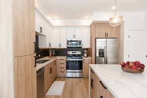 Bozeman apartment for rent - a kitchen with wooden cabinets and stainless steel appliances