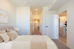 Bozeman apartment for rent - a bedroom with a large bed and a hallway to a bathroom