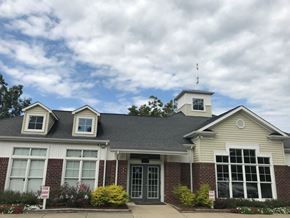 Fayetteville apartment for rent - A building with a grey roof and a white sign in front.