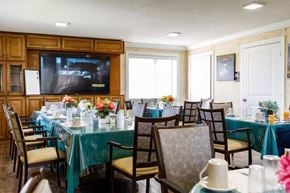 Miami apartment for rent - A dining room with a table set for a meal and a television mounted on the wall.