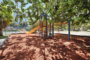 Plantation apartment for rent - A playground with a yellow slide and a red swing set.