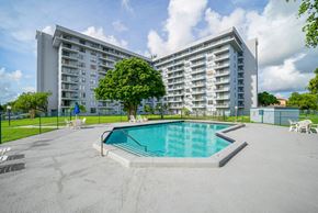 Miami apartment for rent - A large apartment complex with a pool in the foreground.