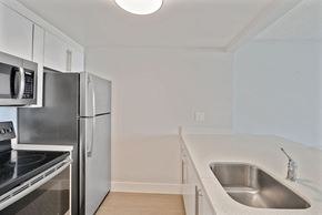 Miami apartment for rent - A kitchen with a sink, refrigerator, and microwave.