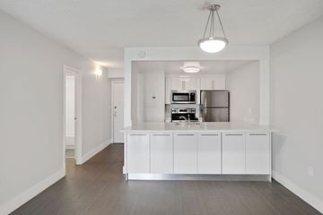 Miami apartment for rent - A kitchen with white cabinets and stainless steel appliances.