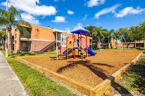 Tampa apartment for rent - A playground with a slide and a wooden fence.