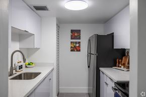 Miami apartment for rent - A kitchen with a black refrigerator and a white counter top.
