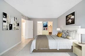 Miami apartment for rent - A bedroom with a large bed and a painting on the wall.