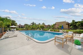West Palm Beach apartment for rent - A pool with a slide and chairs around it.