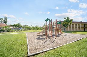 West Palm Beach apartment for rent - A playground with a swing set and a green canopy.