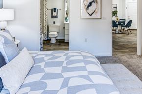 Raleigh apartment for rent - A bedroom with a large bed and a chair in the background.