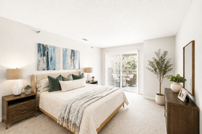 Raleigh apartment for rent - A bedroom with a large bed and a painting on the wall.