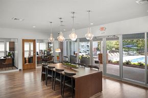 Raleigh apartment for rent - a large dining room with a large table and chairs and a view of a pool