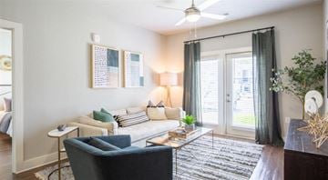 Oakwood apartment for rent - A living room with a blue chair and a white sofa.