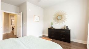 Oakwood apartment for rent - a bedroom with a white bed and a dresser