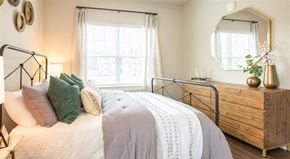 Oakwood apartment for rent - a bedroom with a bed and a dresser and a window