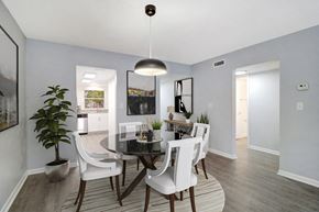 Largo apartment for rent - a dining room with white chairs and a glass table