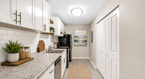 Decatur apartment for rent - A kitchen with white cabinets and a black refrigerator.