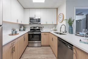 Tampa apartment for rent - a kitchen with stainless steel appliances and white cabinets