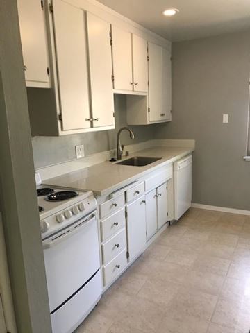 Sacramento apartment for rent - A kitchen with white cabinets and a white stove.