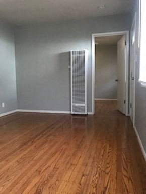 Sacramento apartment for rent - A room with wooden floors and a white door.
