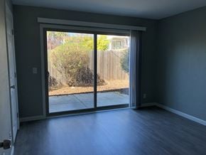 Sacramento apartment for rent - an empty living room with sliding glass doors to a backyard