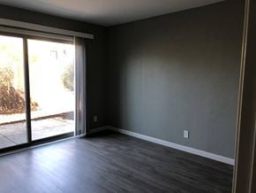 Sacramento apartment for rent - an empty living room with wood floors and a sliding glass door
