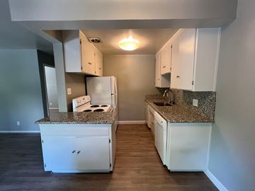 Sacramento apartment for rent - a kitchen with white cabinets and granite counter tops
