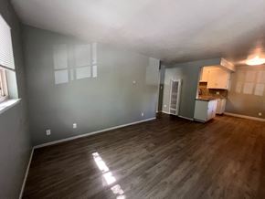 Sacramento apartment for rent - an empty living room with wood floors and a kitchen