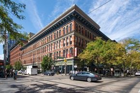 Denver apartment for rent - A large red brick building with a green tree in front of it.