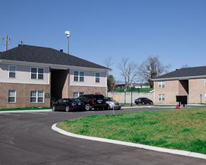 Lawrenceburg apartment for rent - a parking lot in front of two buildings with cars parked
