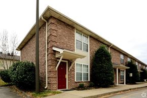 Louisville triplex for rent - A red door is on the left side of a brick house.