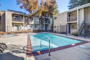 Fairfield apartment for rent - A small pool surrounded by a fence and apartment buildings.