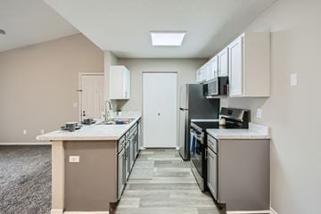 Canal Winchester apartment for rent - A kitchen with a white counter top and a black fridge.