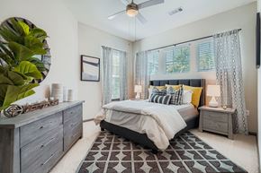 Huntersville apartment for rent - A bedroom with a bed, nightstand, and a plant.