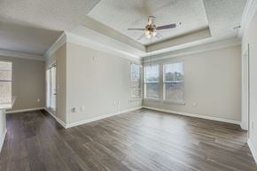 Alpharetta apartment for rent - A spacious room with wooden floors and a ceiling fan.