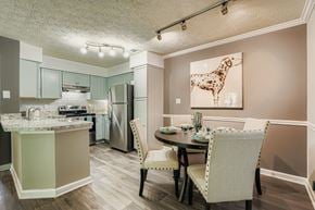 Roswell apartment for rent - A kitchen with a table and chairs and a painting of a giraffe.