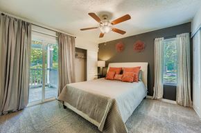 Roswell apartment for rent - Bedroom with a bed, a ceiling fan, and a sliding glass door.