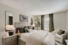 Canal Winchester apartment for rent - A bedroom with a large bed, a nightstand with a lamp, and a painting of a horse on the wall.