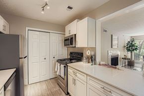 Alpharetta apartment for rent - A kitchen with white cabinets and a black stove top oven.