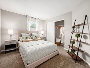 Columbus apartment for rent - A bedroom with a large bed and a wooden ladder.
