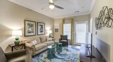 Durham apartment for rent - A living room with a couch, chair, and a table with a green vase on it.