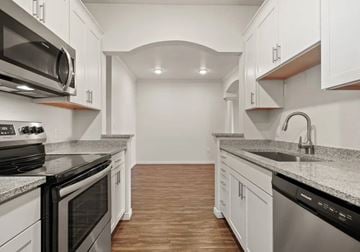 Salt Lake City apartment for rent - A kitchen with white cabinets and a black stove top oven.