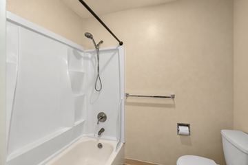 Portland apartment for rent - A white bathtub with a shower head and a towel bar.