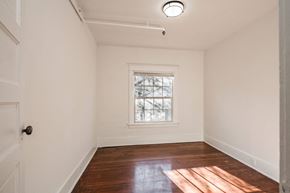 Portland apartment for rent - a living room with white walls and a window and wood floors at Midtown Apartments, Oregon