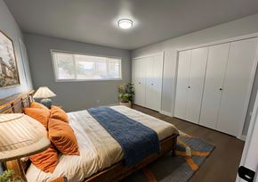 Milwaukie townhouse for rent - A bedroom with a bed, a window, and a lamp.