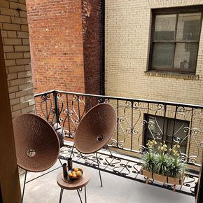 Portland apartment for rent - a balcony with two chairs and plants and a brick building