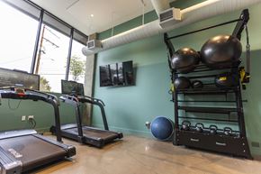 Portland apartment for rent - A gym with treadmills, a rowing machine, and a weight rack at Brookland Apartments, Portland